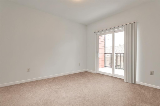 unfurnished room featuring baseboards and light colored carpet