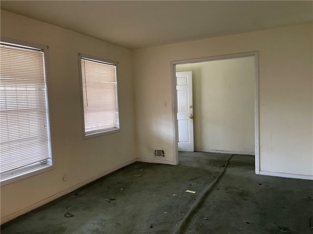 unfurnished room featuring visible vents