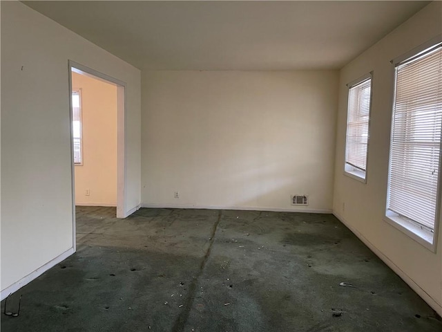 carpeted empty room featuring visible vents and baseboards