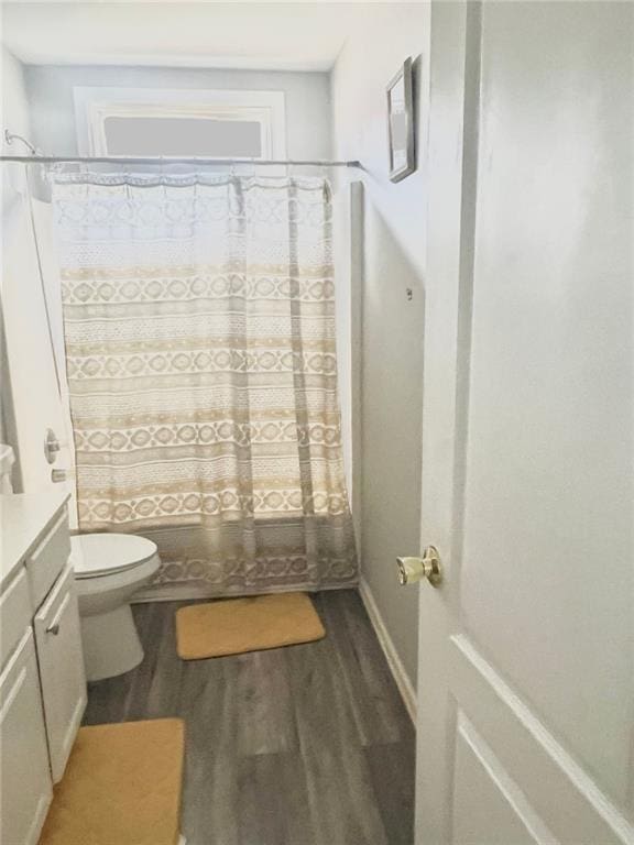 bathroom featuring vanity, curtained shower, wood-type flooring, and toilet