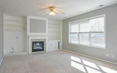 unfurnished living room featuring light colored carpet and ceiling fan