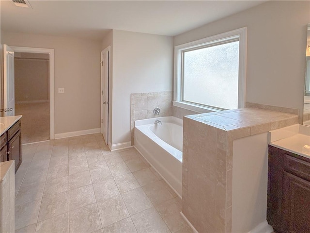 bathroom featuring vanity, a bath, and tile patterned flooring