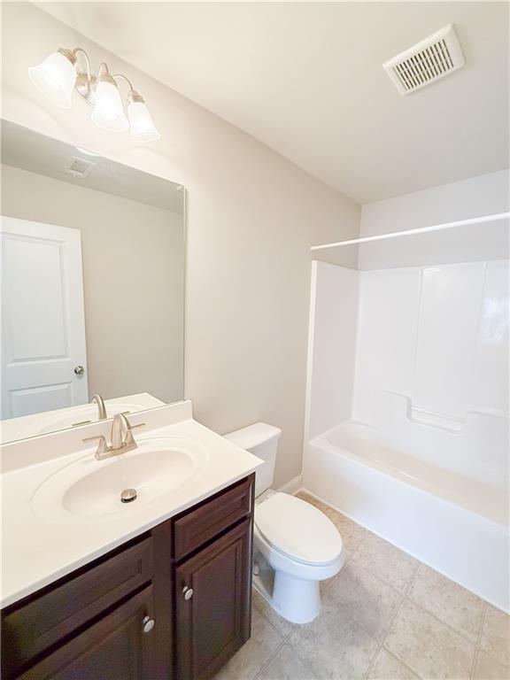 full bathroom with vanity, toilet, and shower / washtub combination