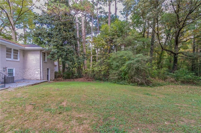 view of yard with central AC unit and a patio