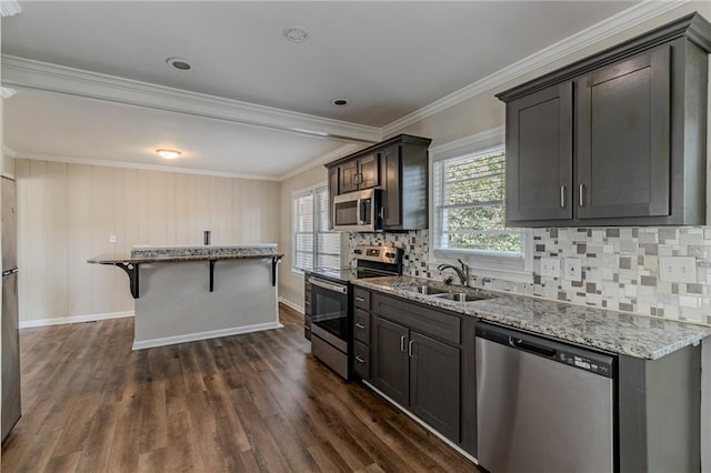 kitchen featuring stainless steel appliances, dark hardwood / wood-style flooring, a center island, sink, and ornamental molding