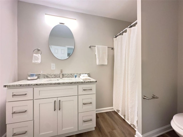 bathroom featuring toilet, vanity, and hardwood / wood-style floors