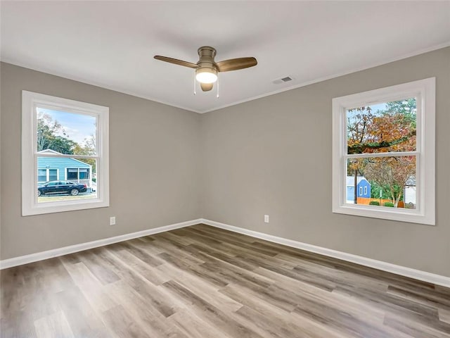 empty room with ceiling fan and light hardwood / wood-style flooring