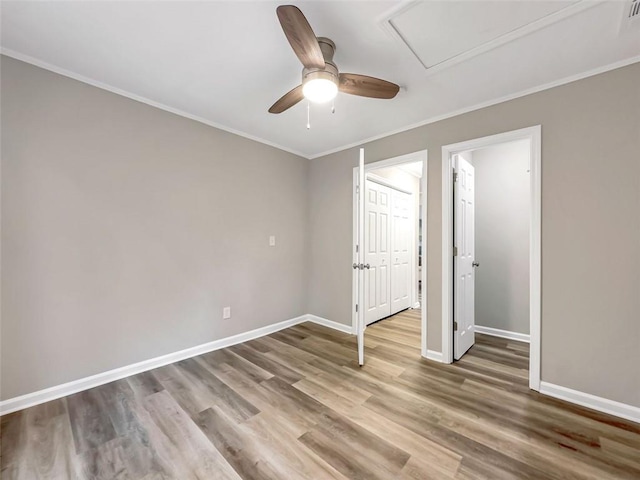 unfurnished bedroom with ceiling fan, a closet, ornamental molding, and hardwood / wood-style floors