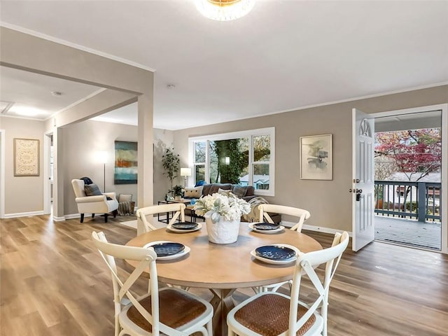 dining area with ornamental molding and hardwood / wood-style flooring