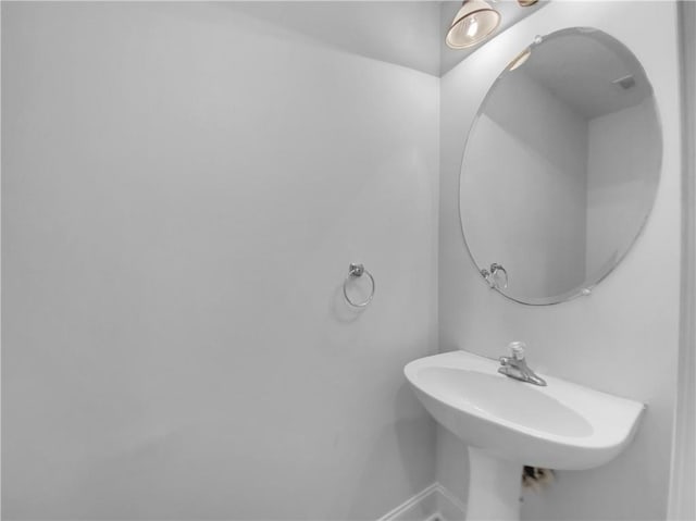 bathroom featuring baseboards and a sink