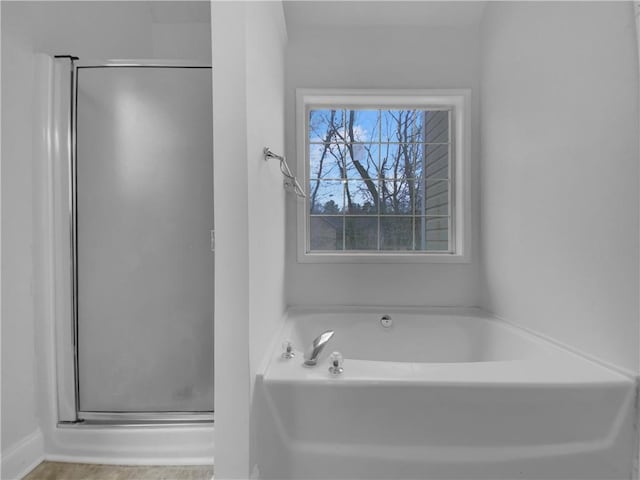 bathroom with a shower stall and a bath