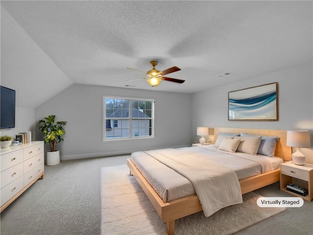 bedroom featuring carpet, ceiling fan, lofted ceiling, and a textured ceiling