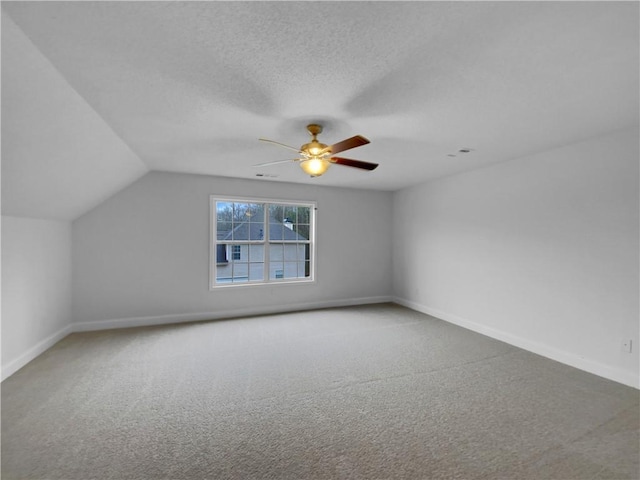 additional living space with a textured ceiling, carpet, and baseboards