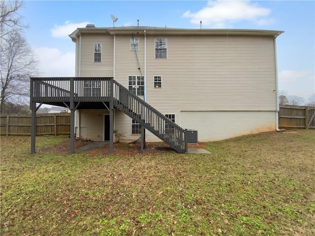 rear view of house featuring a deck, a garage, fence, a yard, and stairway