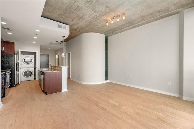 855 Peachtree St NE Unit 3205, Atlanta, GA 30308 - kitchen with estacked washer and dryer, light wood-style flooring, a sink, hanging light fixtures, and light countertops