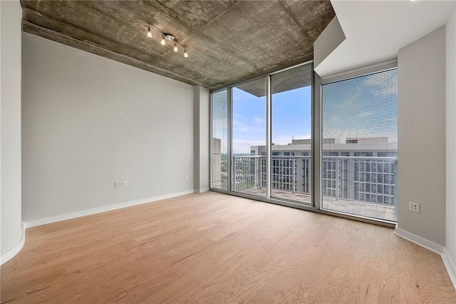855 Peachtree St NE Unit 3205, Atlanta, GA 30308 - unfurnished room featuring a wall of windows, wood finished floors, and baseboards