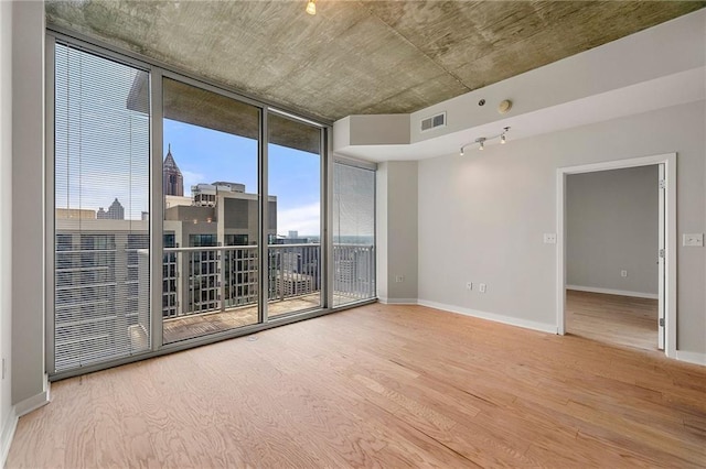 855 Peachtree St NE Unit 3205, Atlanta, GA 30308 - spare room featuring wood finished floors, expansive windows, and baseboards