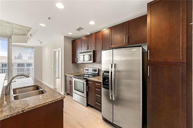 855 Peachtree St NE Unit 3205, Atlanta, GA 30308 - kitchen featuring stainless steel appliances, a sink, decorative backsplash, light wood finished floors, and light stone counters