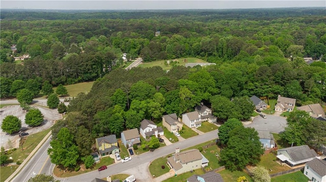 view of property location with a forest and nearby suburban area