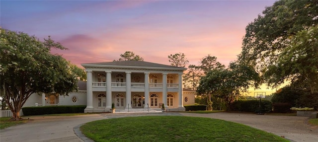 view of front facade with a lawn and a balcony