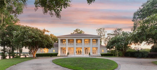 view of front facade featuring a balcony and a yard