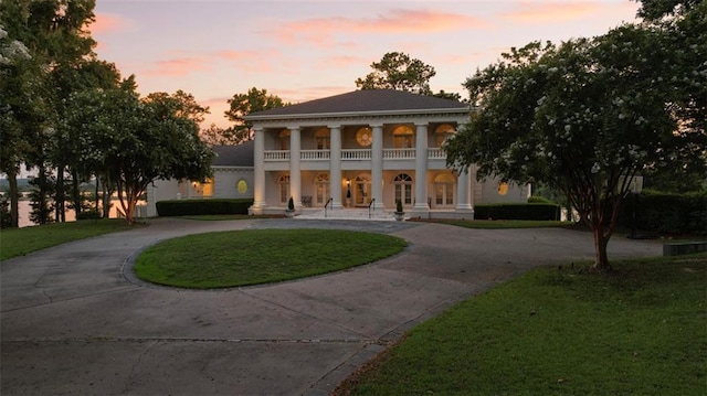 neoclassical / greek revival house with a lawn, a balcony, and a porch