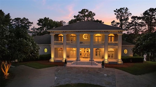 exterior space featuring a balcony, a patio area, and french doors