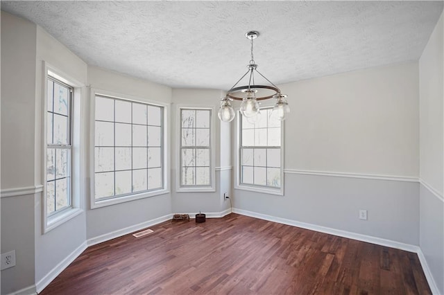 unfurnished dining area featuring baseboards and dark wood-style floors