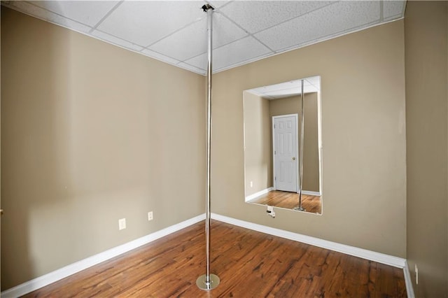 empty room with a drop ceiling and baseboards