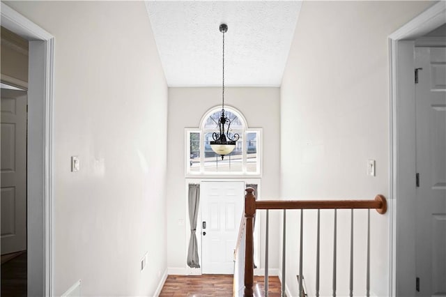 interior space with wood finished floors, visible vents, baseboards, an inviting chandelier, and a textured ceiling