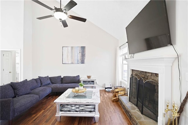 living room featuring high vaulted ceiling, a stone fireplace, wood finished floors, and a ceiling fan