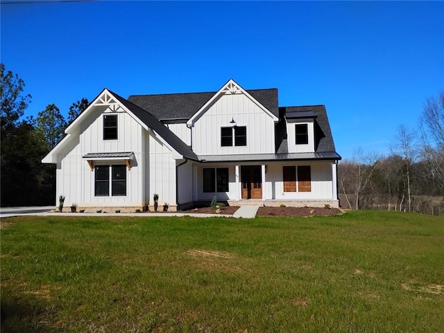 modern farmhouse featuring metal roof, a front lawn, board and batten siding, and roof with shingles