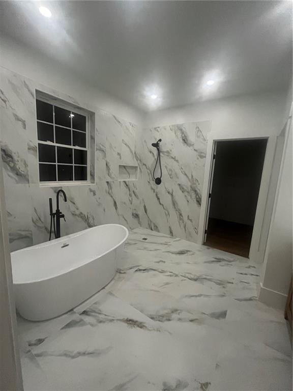 full bathroom with recessed lighting, a freestanding tub, and marble finish floor