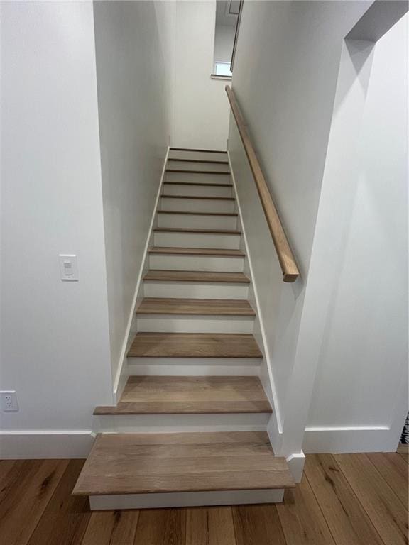 stairway featuring baseboards and wood finished floors