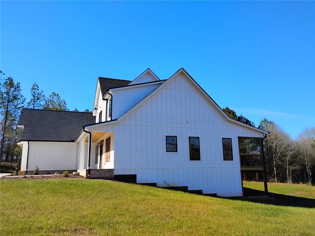 view of property exterior featuring roof with shingles and a yard