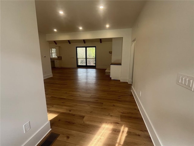 hallway featuring recessed lighting, dark wood-style flooring, visible vents, and baseboards