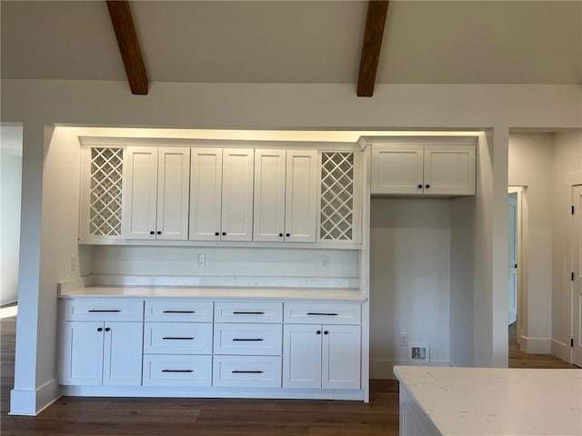 kitchen with white cabinetry, light stone counters, and beam ceiling