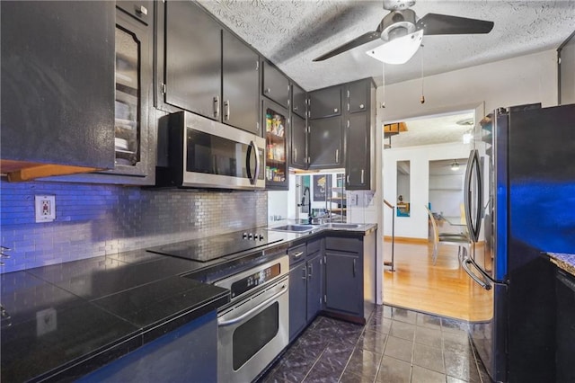 kitchen featuring ceiling fan, tasteful backsplash, a textured ceiling, appliances with stainless steel finishes, and dark hardwood / wood-style flooring