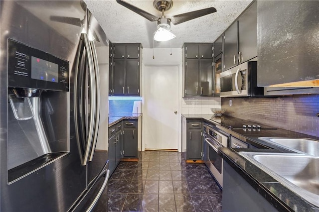 kitchen featuring stainless steel appliances, ceiling fan, tasteful backsplash, and a textured ceiling