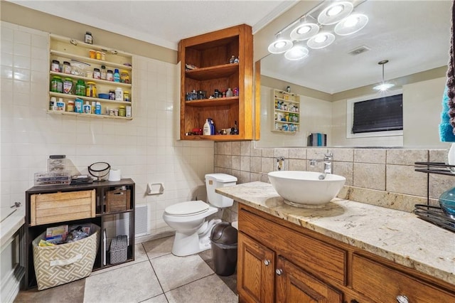 bathroom with tile walls, backsplash, vanity, toilet, and tile patterned floors