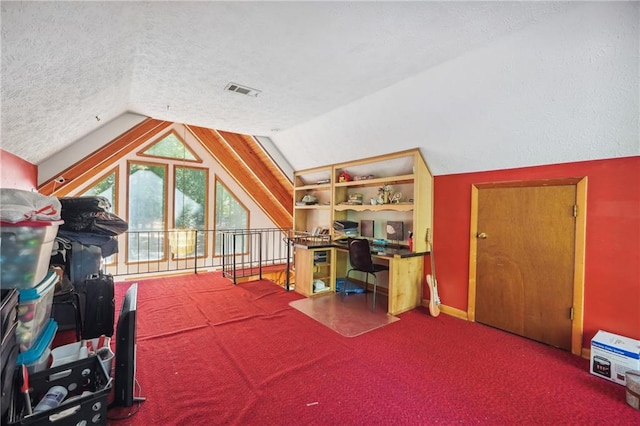 interior space with built in desk, vaulted ceiling, and a textured ceiling