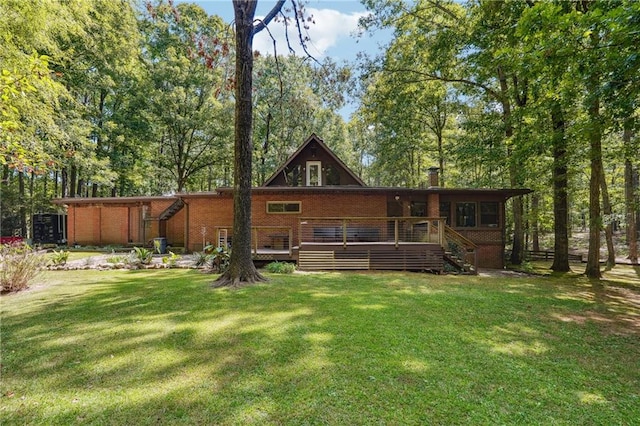 rear view of property with a lawn and a wooden deck