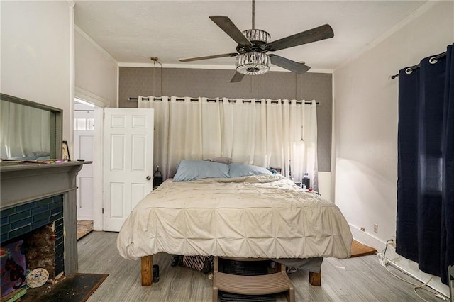 bedroom with ceiling fan, hardwood / wood-style floors, and ornamental molding