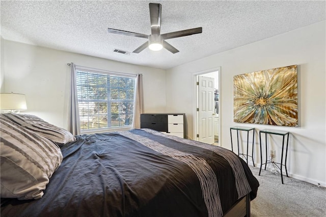 carpeted bedroom featuring ceiling fan and a textured ceiling