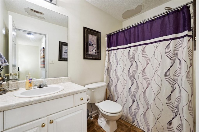 bathroom featuring vanity, a textured ceiling, toilet, and tile patterned flooring