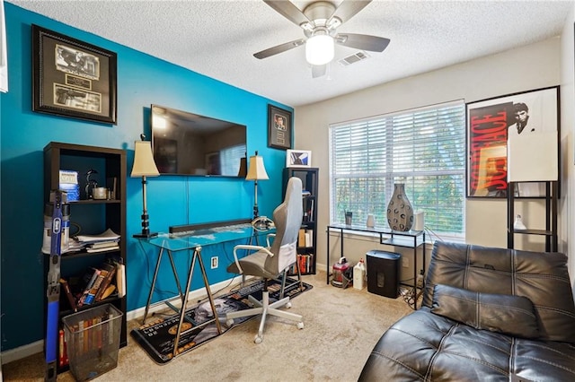 office space featuring carpet flooring, ceiling fan, and a textured ceiling