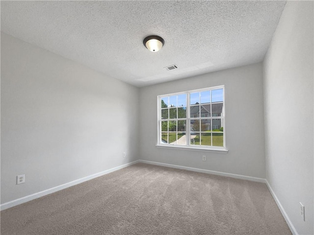 carpeted spare room with a textured ceiling