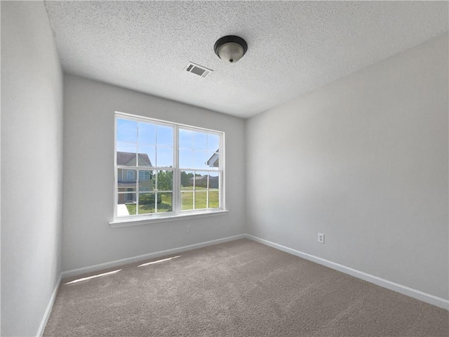 carpeted spare room featuring a textured ceiling