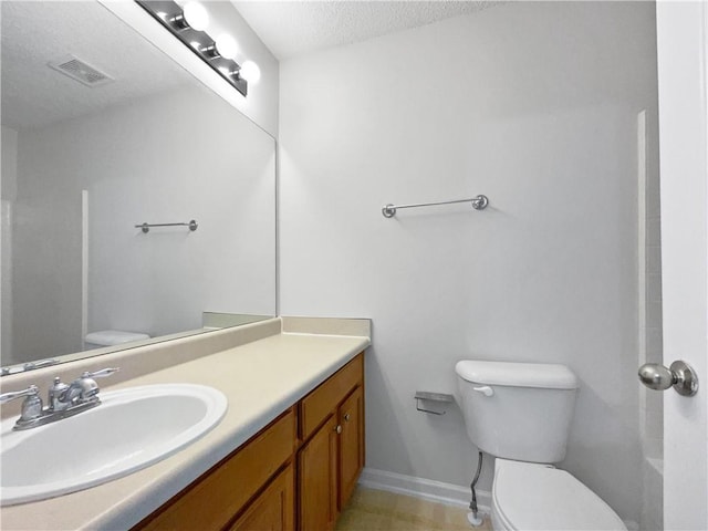 bathroom with vanity, a textured ceiling, and toilet