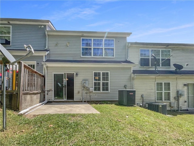 rear view of property featuring a patio, a lawn, and central air condition unit